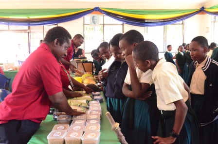 Principal Agricultural Field Officer Mr. James Mwaipyana, showcasing some improved legumes (cowpea, pigeon pea, chickpea, Mungbean) varieties to some students visited TARI Pavilion during Farmers Agricultural Exhibition held at J.K Nyerere Ground Eastern 